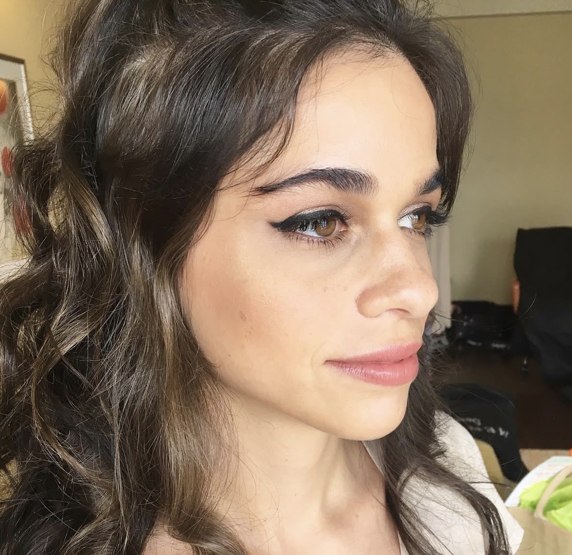 Elegant side profile with winged liner and soft curls